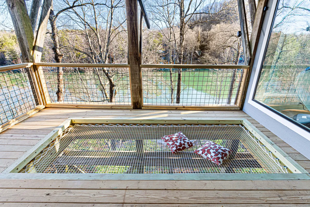 A peaceful wooden deck overlooking the water, adorned with decorative pillows. The setting feels serene and close to nature—an inviting spot for both people and pets to relax and take in the views.